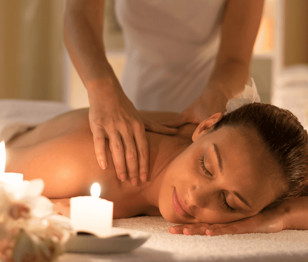 Woman receiving a back massage in a tranquil spa setting.