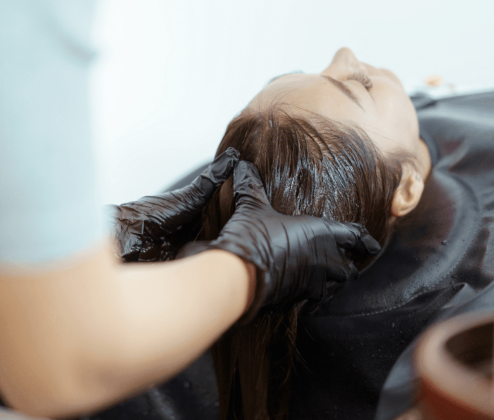 A person receiving a hair treatment at a salon.